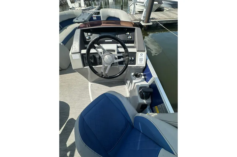 Slide: The Image of 2021 Bennington L Bowrider 25 Swingback helm with blue seating and steering wheel. - 10
