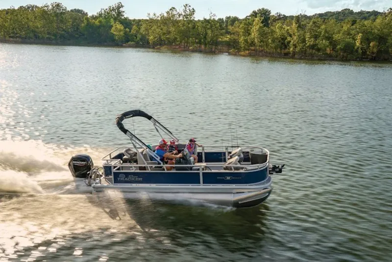 The Image of 2027 Sun Tracker Bass Buggy 18 DLX pontoon boat cruising on a scenic lake. - 2