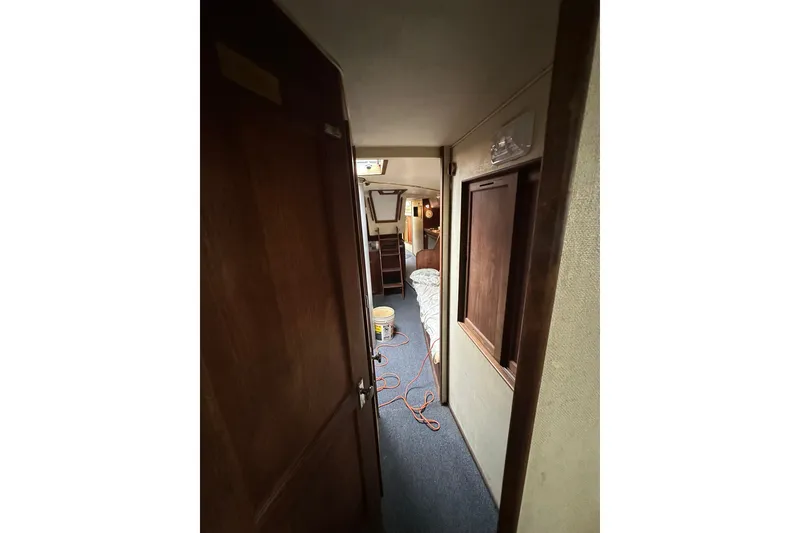 Slide: The Image of Interior view of a 1980 Morgan 415 Ketch sailboat hallway with wooden doors. - 19
