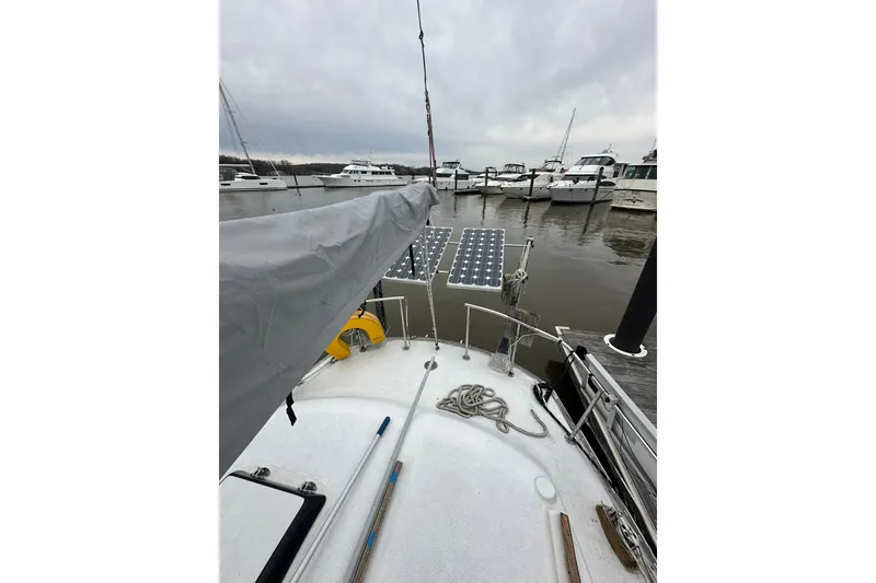 Slide: The Image of 1980 Morgan 415 Ketch sailboat docked, featuring solar panels and a covered boom. - 5