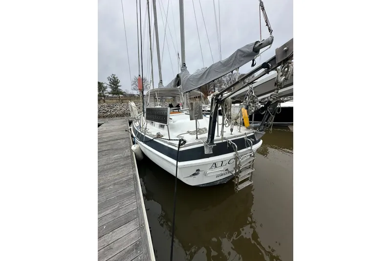 Slide: The Image of 1980 Morgan 415 Ketch sailboat docked, featuring solar panels and rigging, overcast sky. - 4