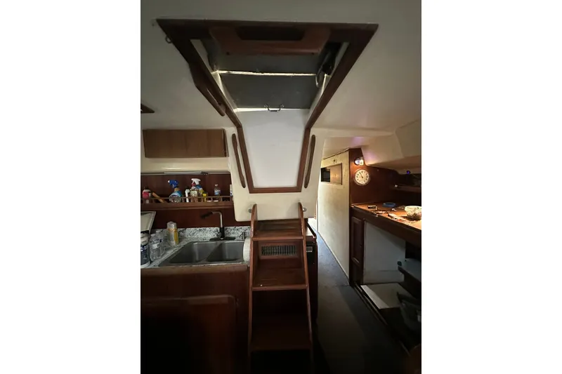 Slide: The Image of Interior of 1980 Morgan 415 Ketch sailboat with wooden cabinetry and compact kitchen area. - 22