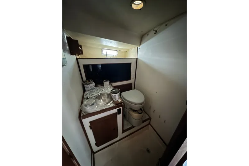 Slide: The Image of 1980 Morgan 415 Ketch boat bathroom with sink, toilet, and storage cabinets. - 17