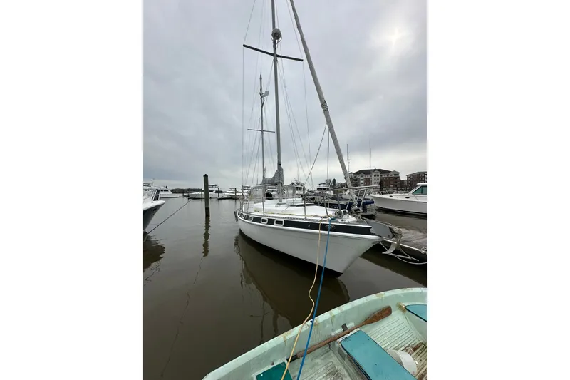 The Image of 1980 Morgan 415 Ketch sailboat docked at a marina on a cloudy day. - 1