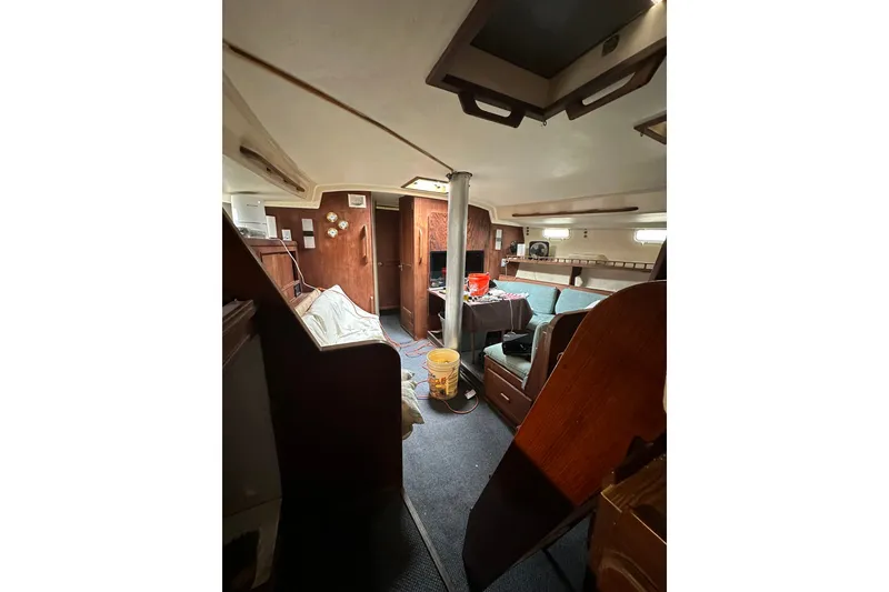 Slide: The Image of Interior of a 1980 Morgan 415 Ketch sailboat, featuring wood paneling and seating area. - 14