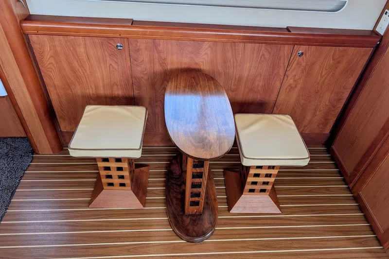 Slide: The Image of Interior of 2008 Mainship 34 Trawler with wooden table and cushioned stools. - 23