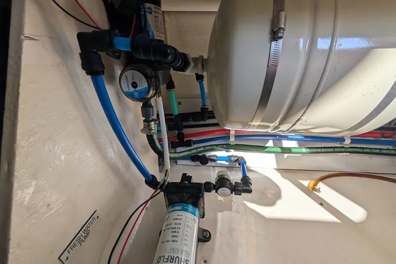 Slide: The Image of Engine room of 2008 Mainship 34 Trawler showing plumbing and water pump system. - 48