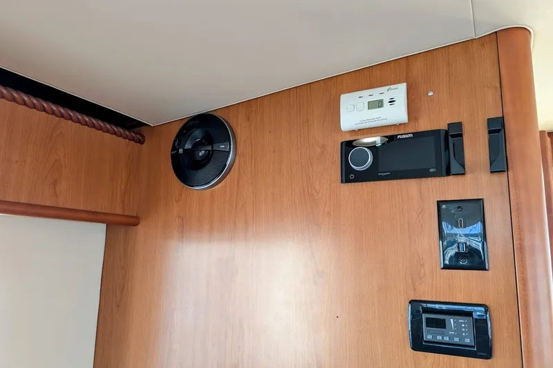 Slide: The Image of 2008 Mainship 34 Trawler interior with speaker, control panel, and wood finish. - 35