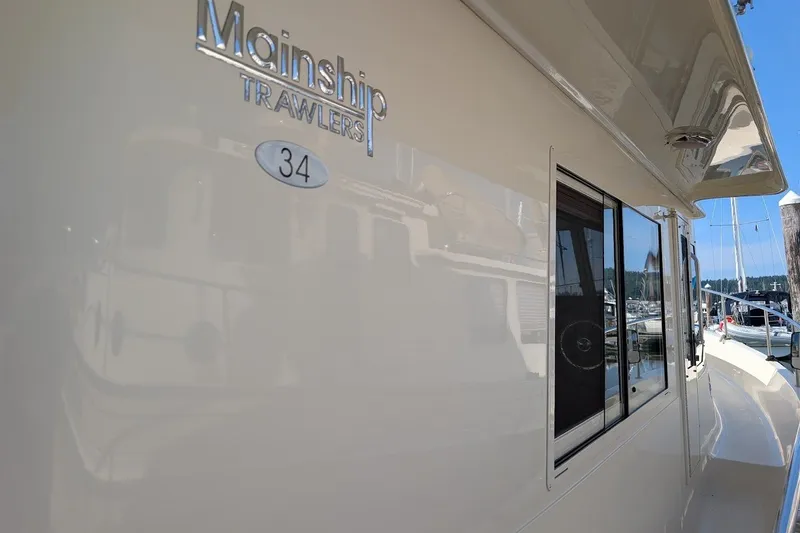 Slide: The Image of Side view of a 2008 Mainship 34 Trawler yacht docked at a marina. - 38