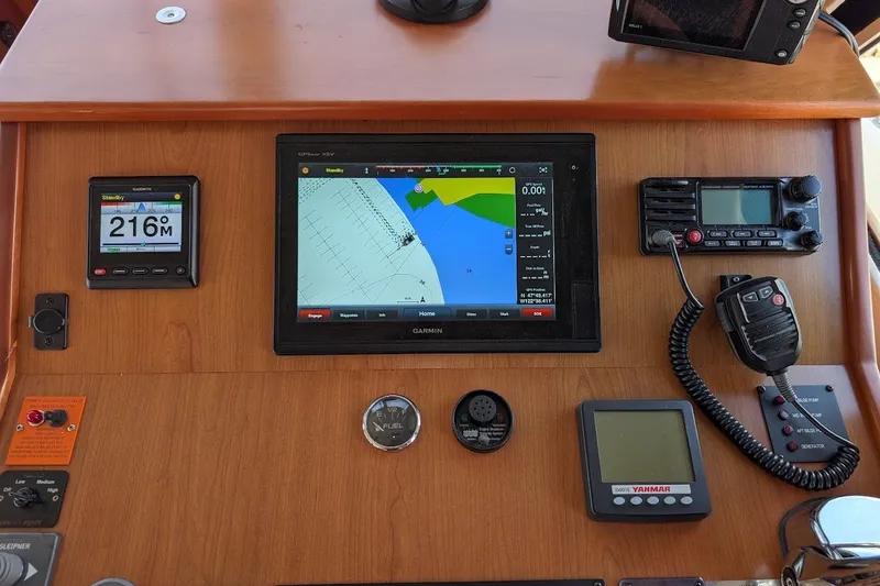 Slide: The Image of Navigation dashboard of a 2008 Mainship 34 Trawler with Garmin GPS and communication devices. - 33