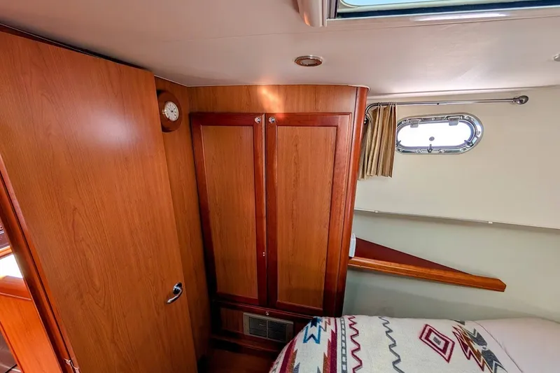 Slide: The Image of Interior cabin of 2008 Mainship 34 Trawler with wood paneling and nautical decor. - 27