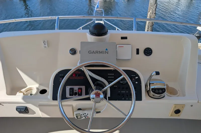 Slide: The Image of 2008 Mainship 34 Trawler helm with Garmin navigation, steering wheel, and controls. - 37