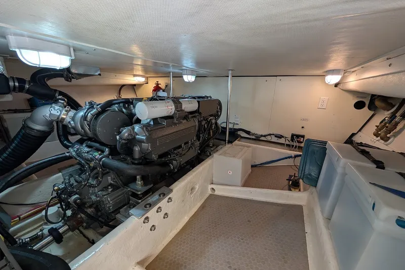 Slide: The Image of Engine room of 2008 Mainship 34 Trawler, showcasing mechanical components and storage. - 46