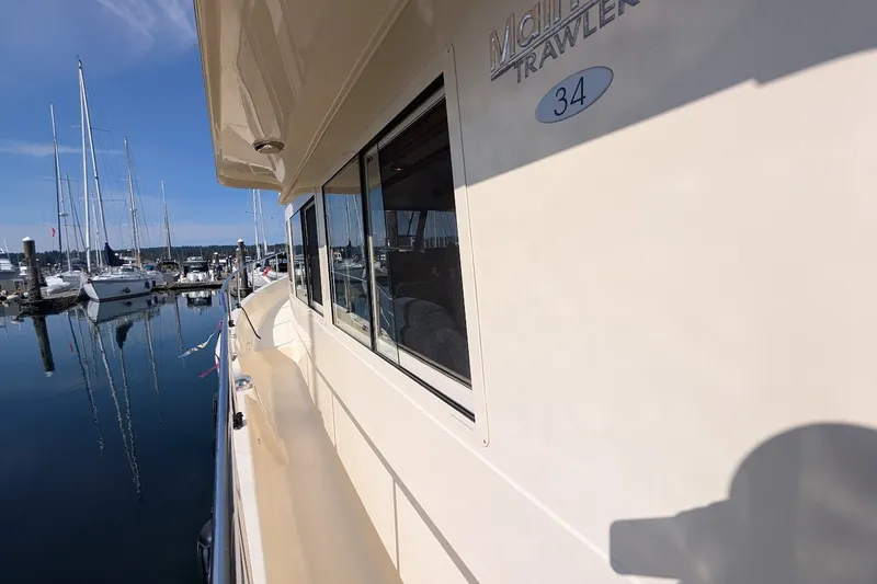 Slide: The Image of 2008 Mainship 34 Trawler docked at marina, reflecting on calm water. - 41