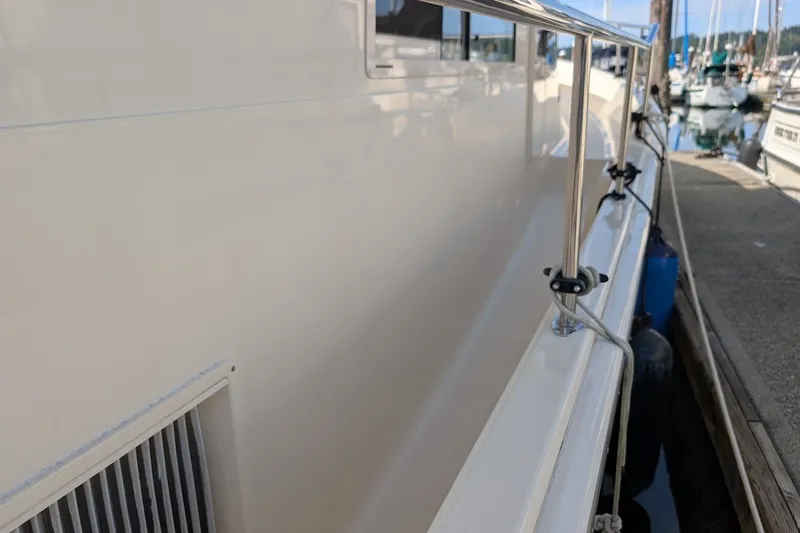 Slide: The Image of 2008 Mainship 34 Trawler docked, showcasing side railing and marina setting. - 39
