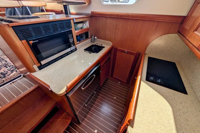 Slide: The Image of 2008 Mainship 34 Trawler galley with microwave, sink, and stovetop. - 21