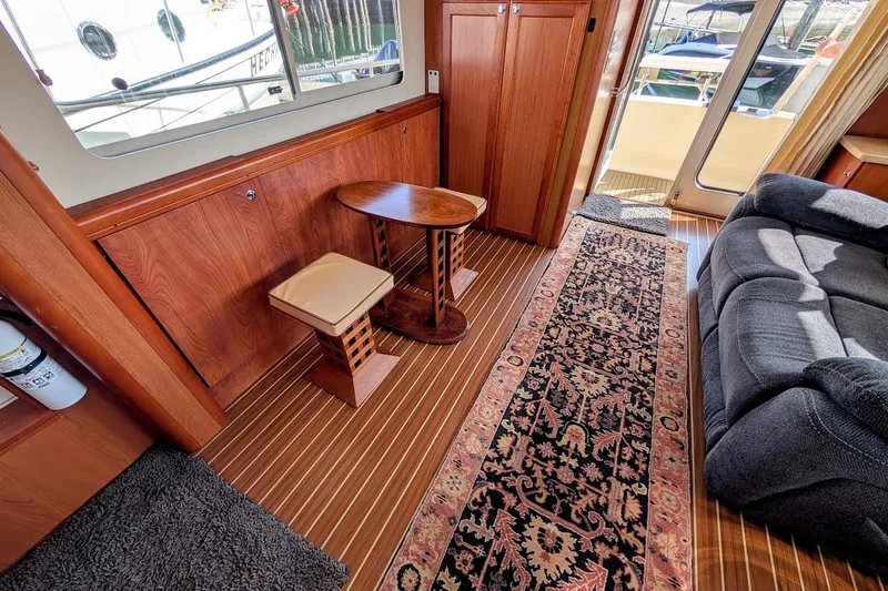 Slide: The Image of Interior of 2008 Mainship 34 Trawler with wood paneling, seating, and patterned rug. - 22