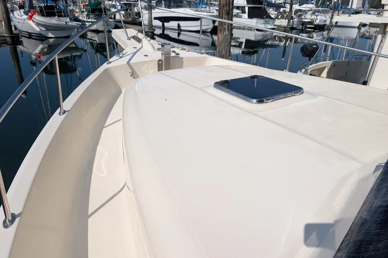 Slide: The Image of 2008 Mainship 34 Trawler deck view at marina, showcasing sleek design and railing. - 14