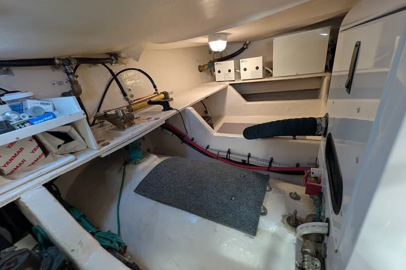Slide: The Image of Engine room of 2008 Mainship 34 Trawler, showcasing mechanical components and storage areas. - 51