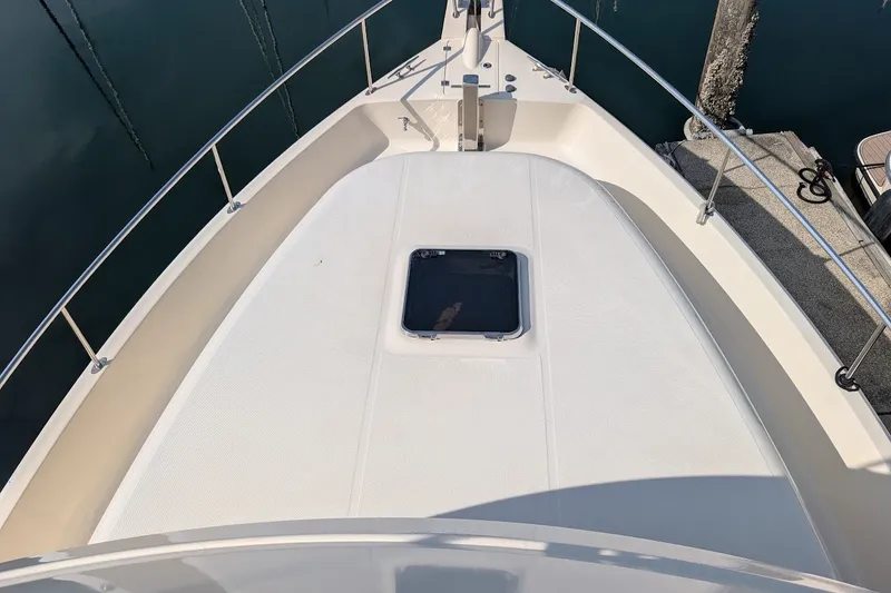 Slide: The Image of 2008 Mainship 34 Trawler bow deck with hatch, docked at marina. - 15