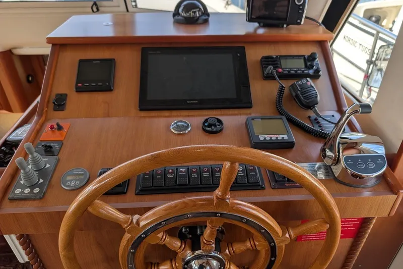 Slide: The Image of 2008 Mainship 34 Trawler helm with wooden wheel and navigation instruments. - 32