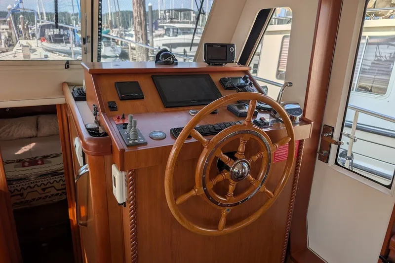 Slide: The Image of 2008 Mainship 34 Trawler helm with wooden wheel and navigation instruments. - 31