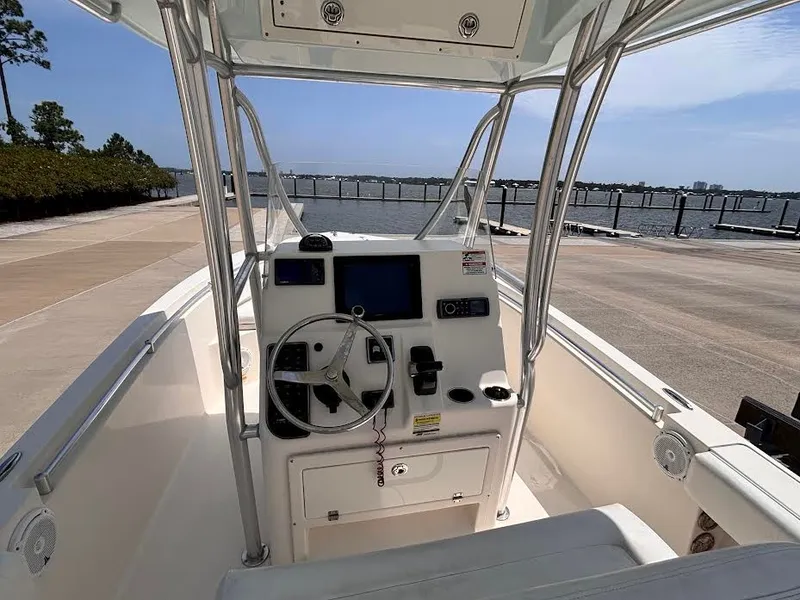 Slide: The Image of The image shows the helm of a 2014 Cobia 237 Center Console boat. It is docked with a view of the water. - 15