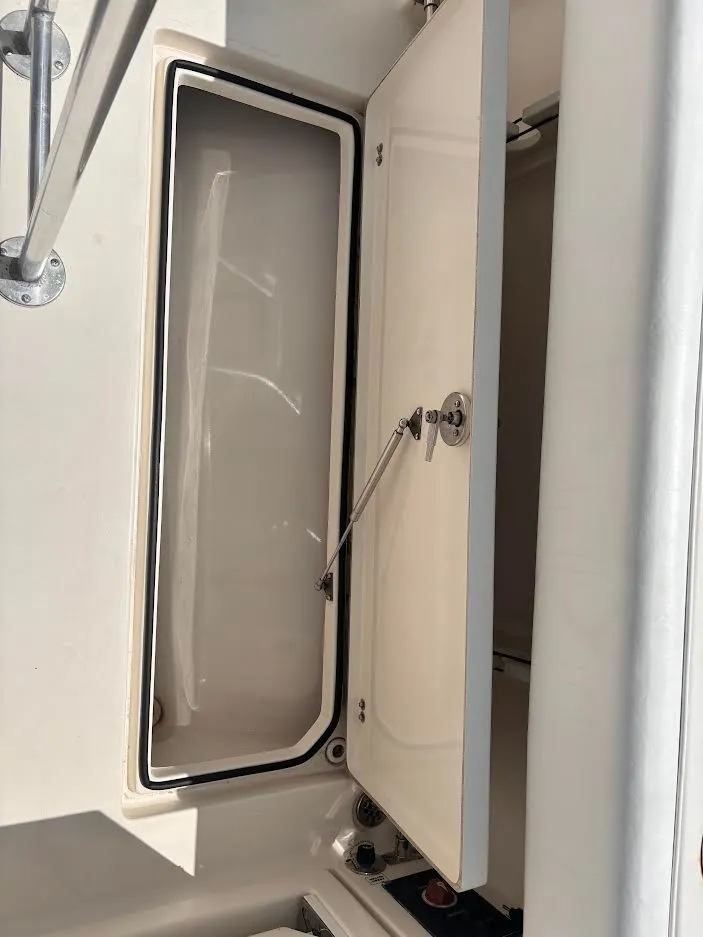 Slide: The Image of An open storage compartment on a 2014 Cobia 237 Center Console boat. - 14