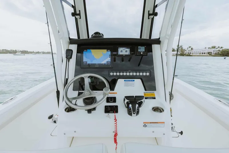 The Image of Manufacturer Provided Image: 2025 World Cat 235 TE boat dashboard with steering wheel and navigation screens on open water. - 5