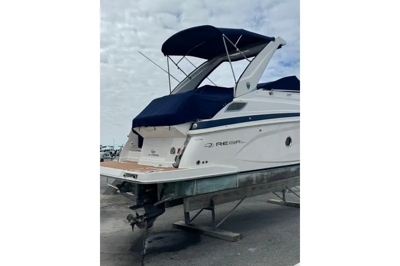 Slide: The Image of 2018 Regal 28 Express boat with blue canopy on a trailer. - 2