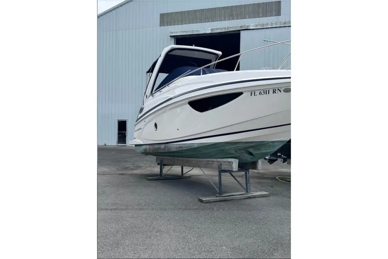 Slide: The Image of 2018 Regal 28 Express boat on stands outside a large building. - 3