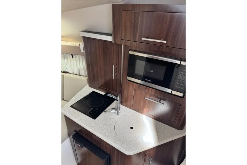 Slide: The Image of Compact kitchen area in 2018 Regal 28 Express boat with microwave and stovetop. - 14