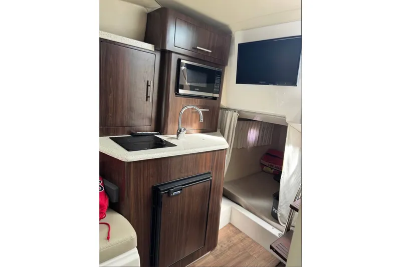 Slide: The Image of Interior of 2018 Regal 28 Express boat with kitchenette and TV. - 12