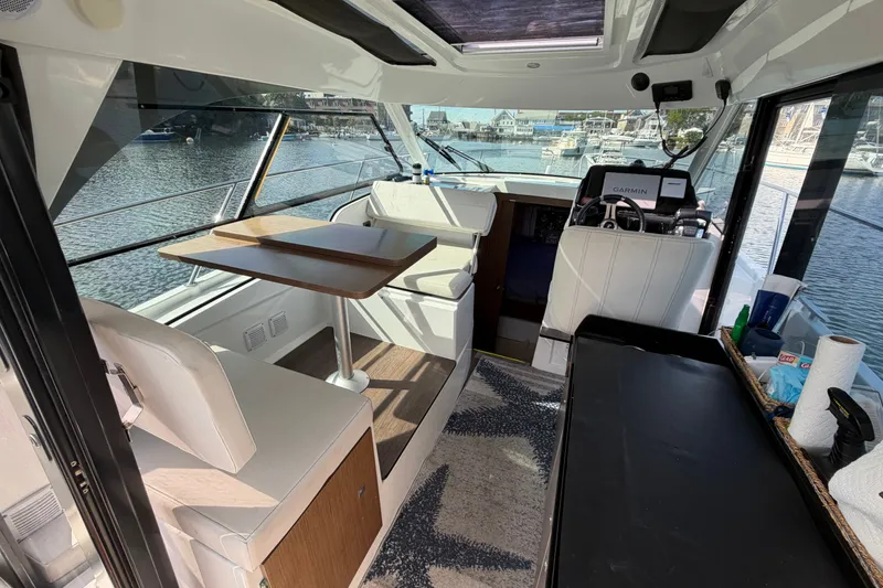 Slide: The Image of Interior of 2021 Beneteau Antares 27 boat with seating, table, and navigation equipment. - 10