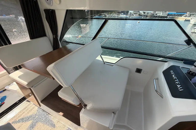 Slide: The Image of Interior of 2021 Beneteau Antares 27, featuring seating and table with waterfront view. - 16