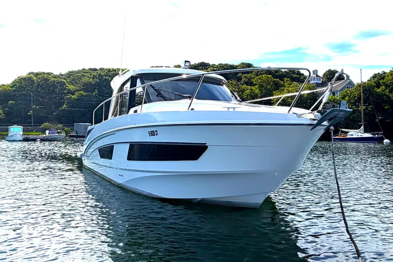 Slide: The Image of 2021 Beneteau Antares 27 boat anchored in a scenic harbor setting. - 4