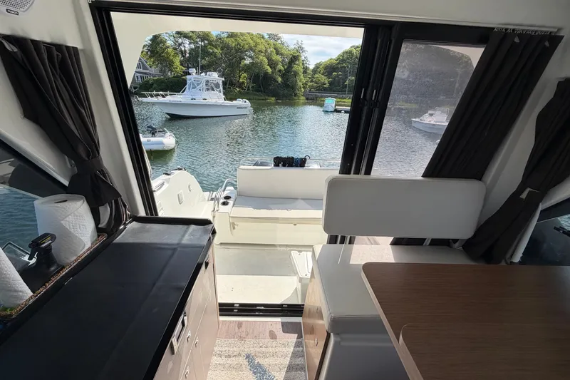 Slide: The Image of Interior view of 2021 Beneteau Antares 27 yacht overlooking serene waters and boats. - 14