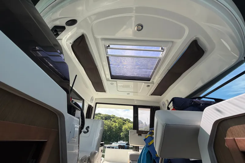Slide: The Image of Interior view of 2021 Beneteau Antares 27 boat with skylight and seating. - 33