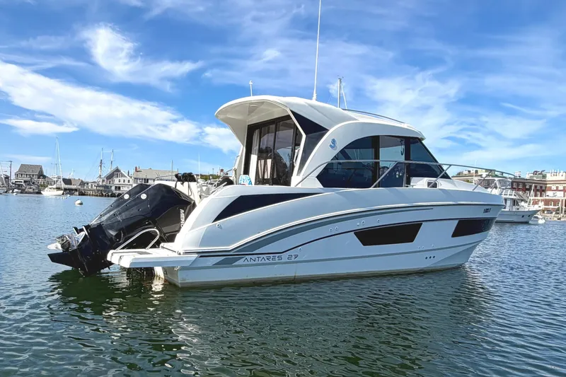 The Image of 2021 Beneteau Antares 27 boat docked in a scenic harbor. - 1