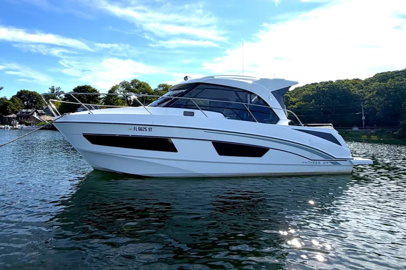 Slide: The Image of 2021 Beneteau Antares 27 boat on calm water under a clear blue sky. - 6