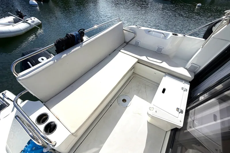 Slide: The Image of Beneteau Antares 27 (2021) boat deck with seating and storage, docked on calm water. - 9