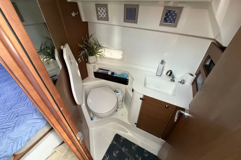 Slide: The Image of Bathroom interior of 2021 Beneteau Antares 27 boat, featuring toilet, sink, and storage. - 30