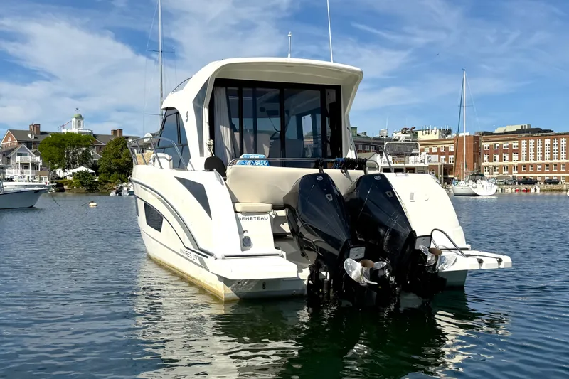 Slide: The Image of 2021 Beneteau Antares 27 boat with dual engines docked in a scenic harbor. - 3