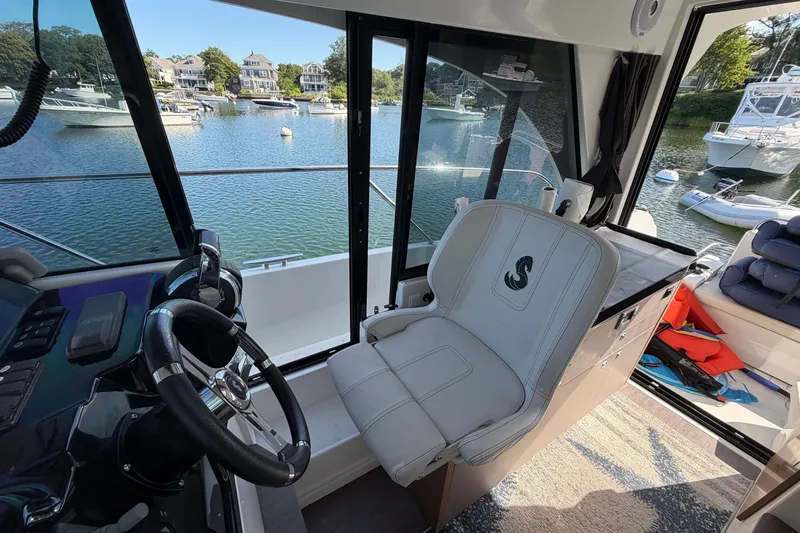 Slide: The Image of Interior view of 2021 Beneteau Antares 27 boat, featuring helm and seating area. - 19