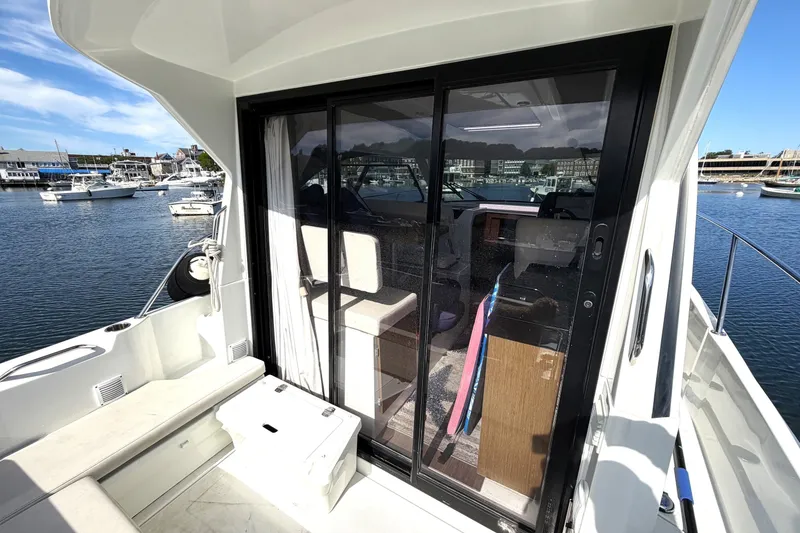 Slide: The Image of Beneteau Antares 27 (2021) boat with sliding glass doors, docked at a marina. - 8