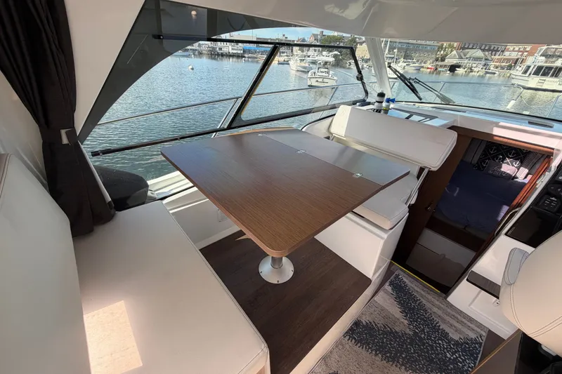 Slide: The Image of Interior of 2021 Beneteau Antares 27 with dining area and marina view. - 15