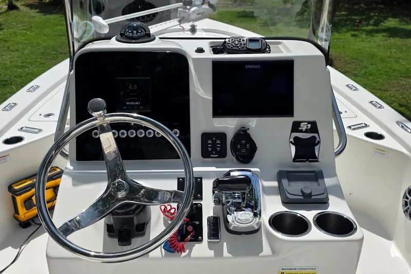 Slide: The Image of 2021 Sea Pro 228 Bay boat dashboard with steering wheel and navigation controls. - 15