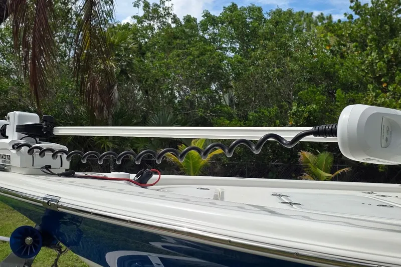Slide: The Image of 2021 Sea Pro 228 Bay boat with trolling motor, surrounded by lush greenery. - 21