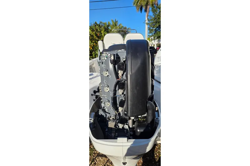 Slide: The Image of 2021 Sea Pro 228 Bay boat engine, detailed view under clear blue sky. - 34