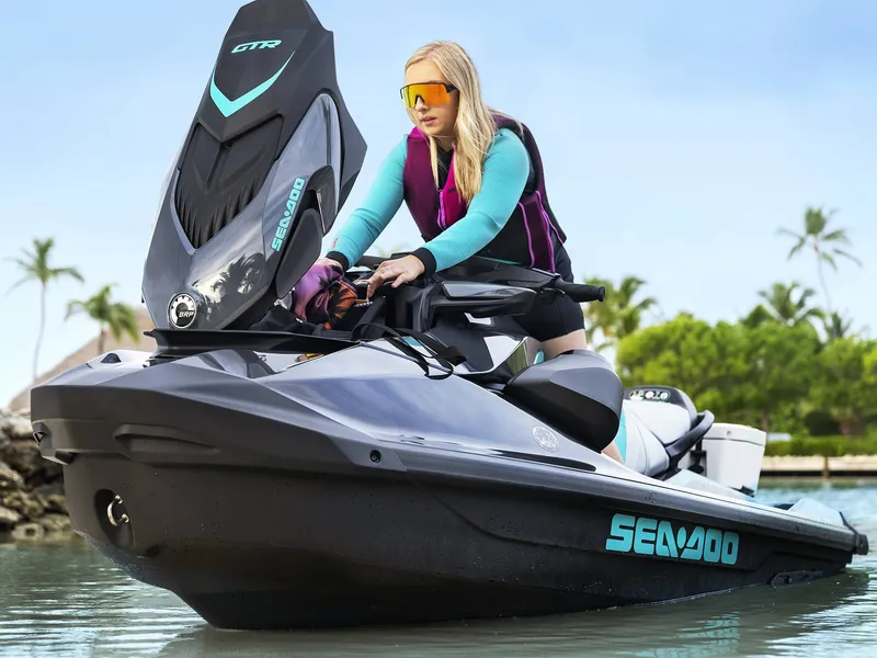 Slide: The Image of A person sits on a Sea-Doo GTR 230 jet ski in the water, surrounded by palm trees. - 11
